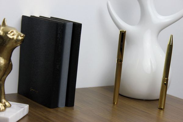 blue and black travel journal with gold pen